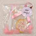 Kant-en-klare roze geboorte traktatie in cellofaan zakje met een geboortekoekje met muisjes, roze toeter, roze confetti en een gepersonaliseerde sticker van Mila Strakteert