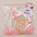 Kant-en-klare roze geboorte traktatie in cellofaan zakje met een geboortekoekje met muisjes, roze toeter, roze confetti en een gepersonaliseerde sticker van Mila Strakteert