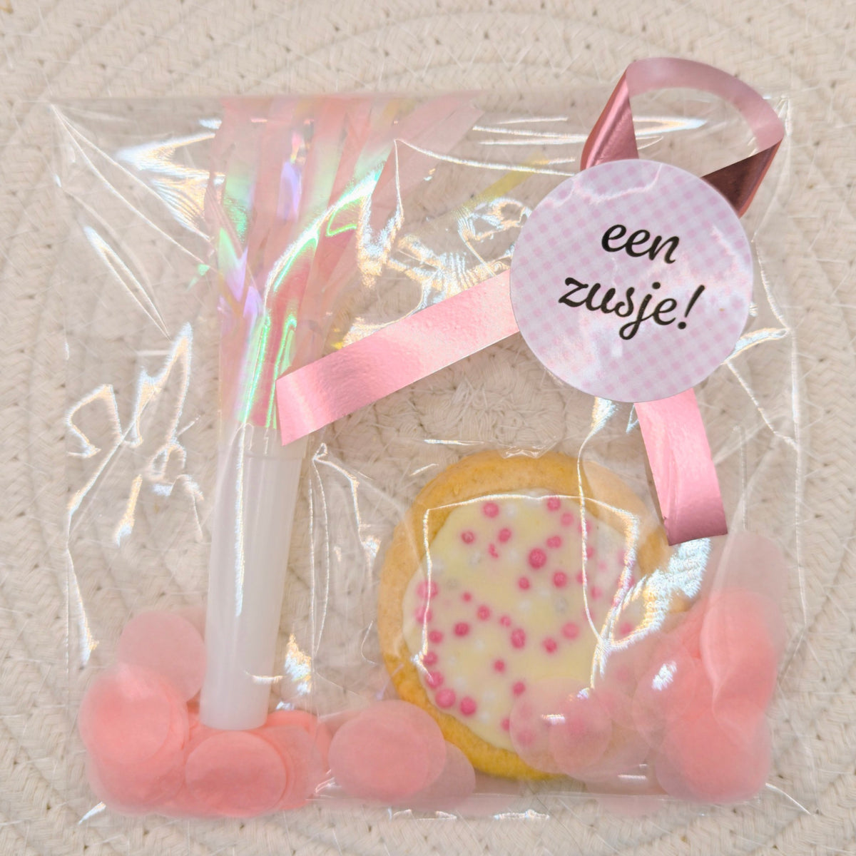 Kant-en-klare roze geboorte traktatie in cellofaan zakje met een geboortekoekje met muisjes, roze toeter, roze confetti en een gepersonaliseerde sticker van Mila Strakteert