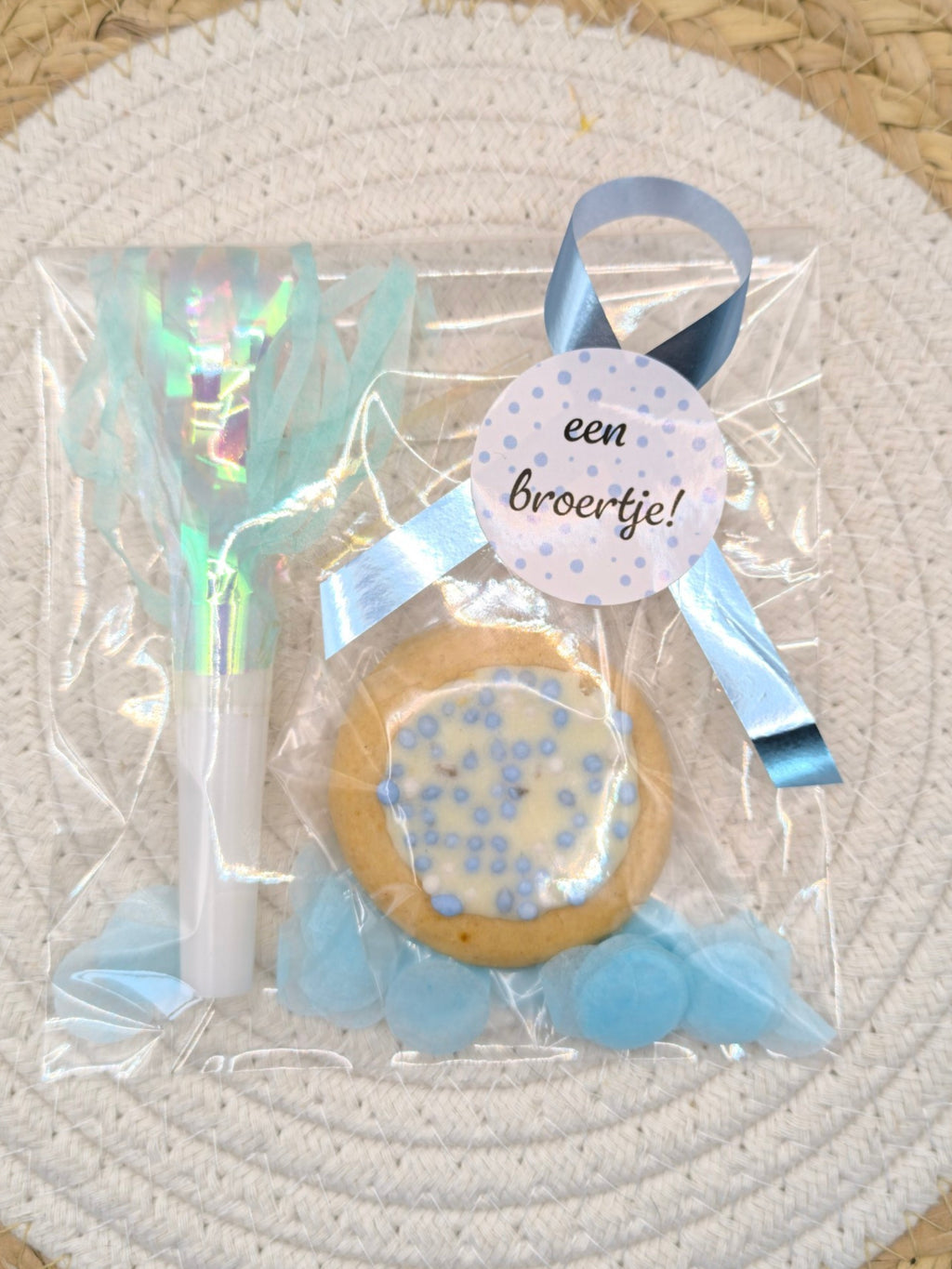 Kant-en-klare geboortetraktatie van Mila Trakteert met een blauw geboortekoekje in een cellofaanzakje met blauwe confetti, een blauwe toeter en een sluitsticker met de tekst Een broertje verschillende varianten.